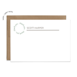 Image of a white flat note card and a kraft brown envelope. The card has the words “thank you” repeating in a circle shape in the top left corner and an example of a name with a line beneath the name.