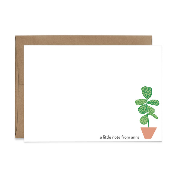 An image of a flat note and a kraft brown envelope. The card has an illustrated fiddle leaf fig potted plant and an example of a name in the bottom right corner.