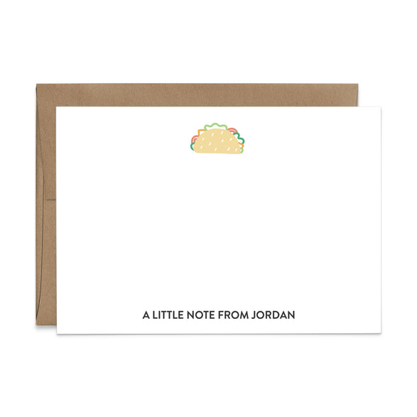 Image of a white flat note card and a kraft brown envelope. The card has a cute taco illustration at the top and an example of a name at the bottom.