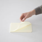 An image of someone lifting a page from the notepad