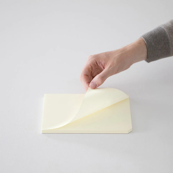 An image of someone lifting a page from the notepad