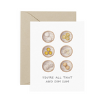 A folded greeting card with text that reads "You're all that and dim sum" with illustrated different types of dumplings. Card is lying on a light tan envelope.