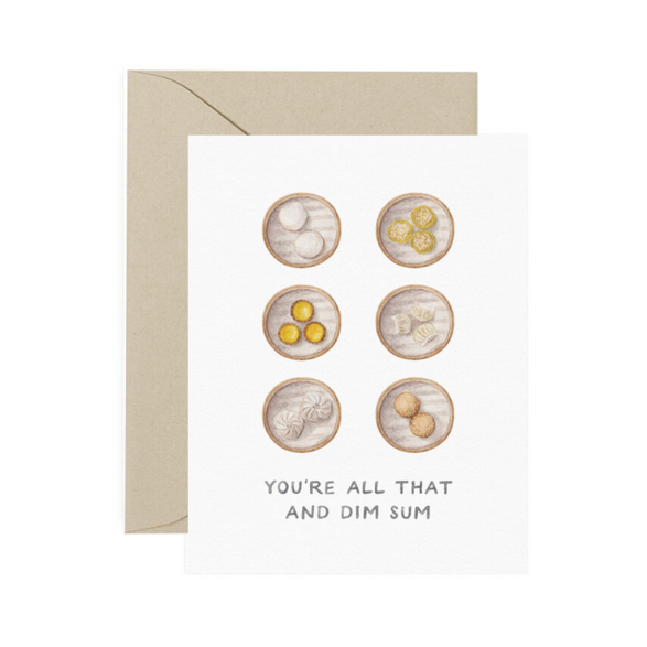 A folded greeting card with text that reads "You're all that and dim sum" with illustrated different types of dumplings. Card is lying on a light tan envelope.