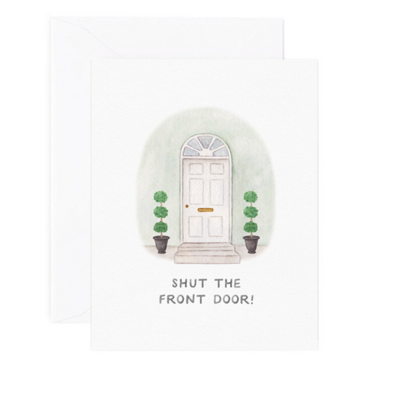 A folded greeting card with text that reads "Shut the front door!" with an illustrated house front doorstep. Card is lying on white envelope.