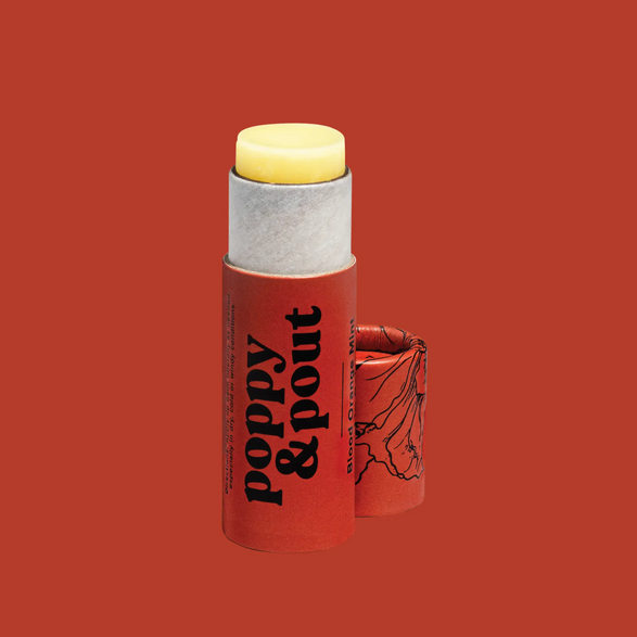 Image of a open lip balm with a dark red paperboard tube and text "poppy & pout" on a dark red background