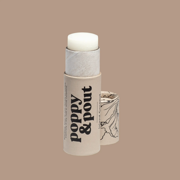 Image of an open beige lip balm paperboard tube with text "poppy and pout"  on a light brown background