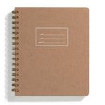 An image of a kraft notebook with gold spiral binding on a white background. The cover of the notebook has a small section to label the name, date and subject.