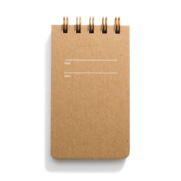An image of a small reporter notebook with a kraft cover